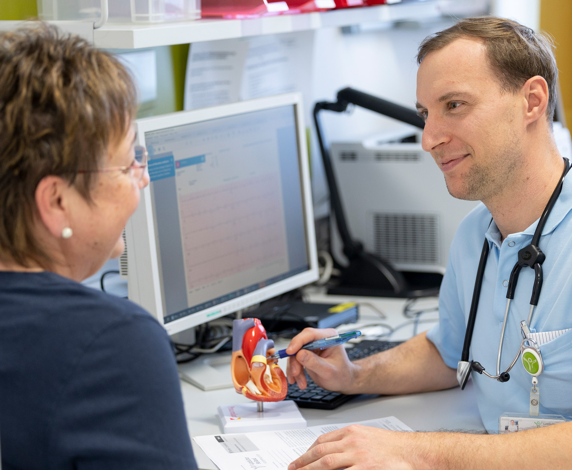 Ein Arzt bespricht ein EKG mit einer Patientin