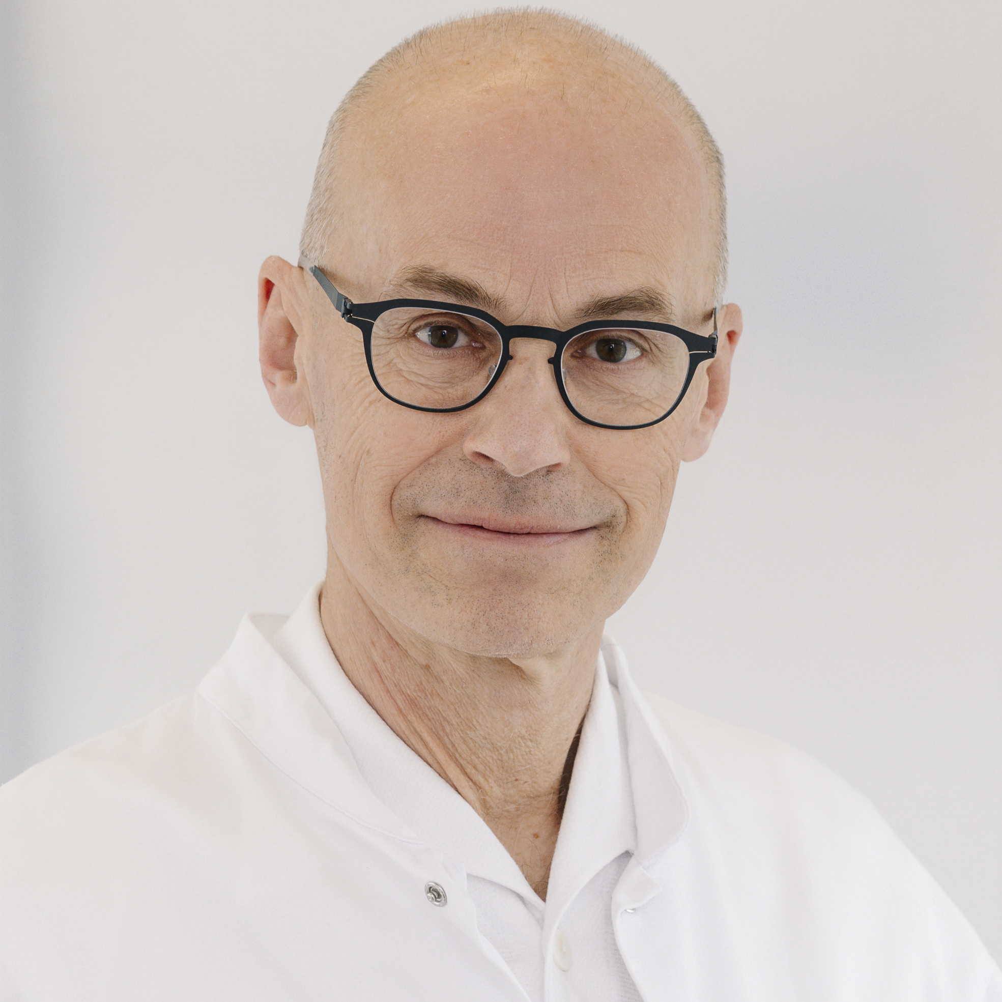 Ein Mann mit Glatze und Brille
