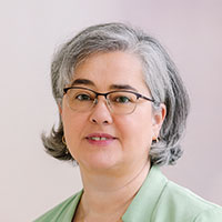 Portraitbild einer Frau mit grauen kinnlangen Haaren und Brille