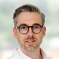 Ein Mann mit kurzen Haaren und Brille