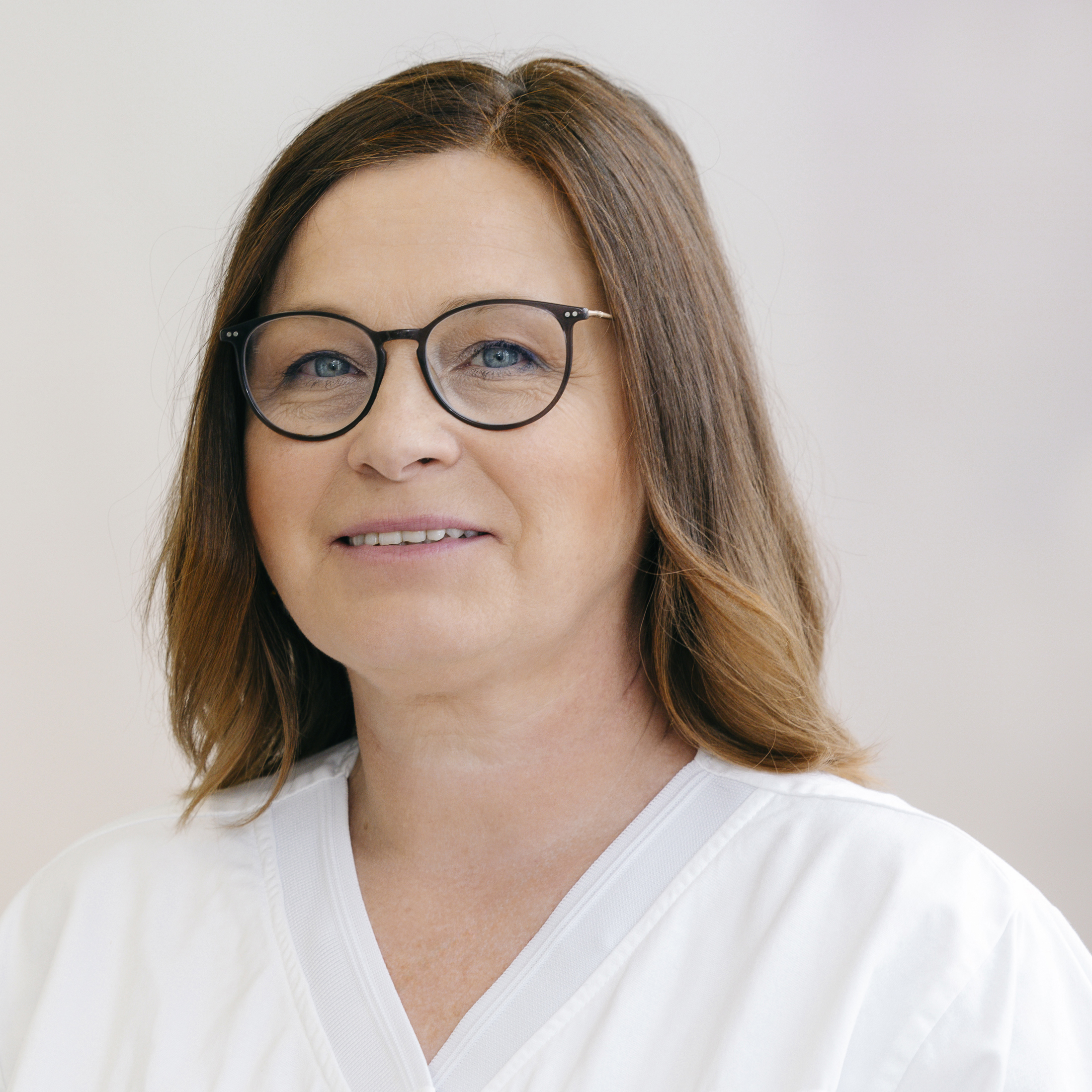 Frau mit mittellangen braunen Haaren und Brille