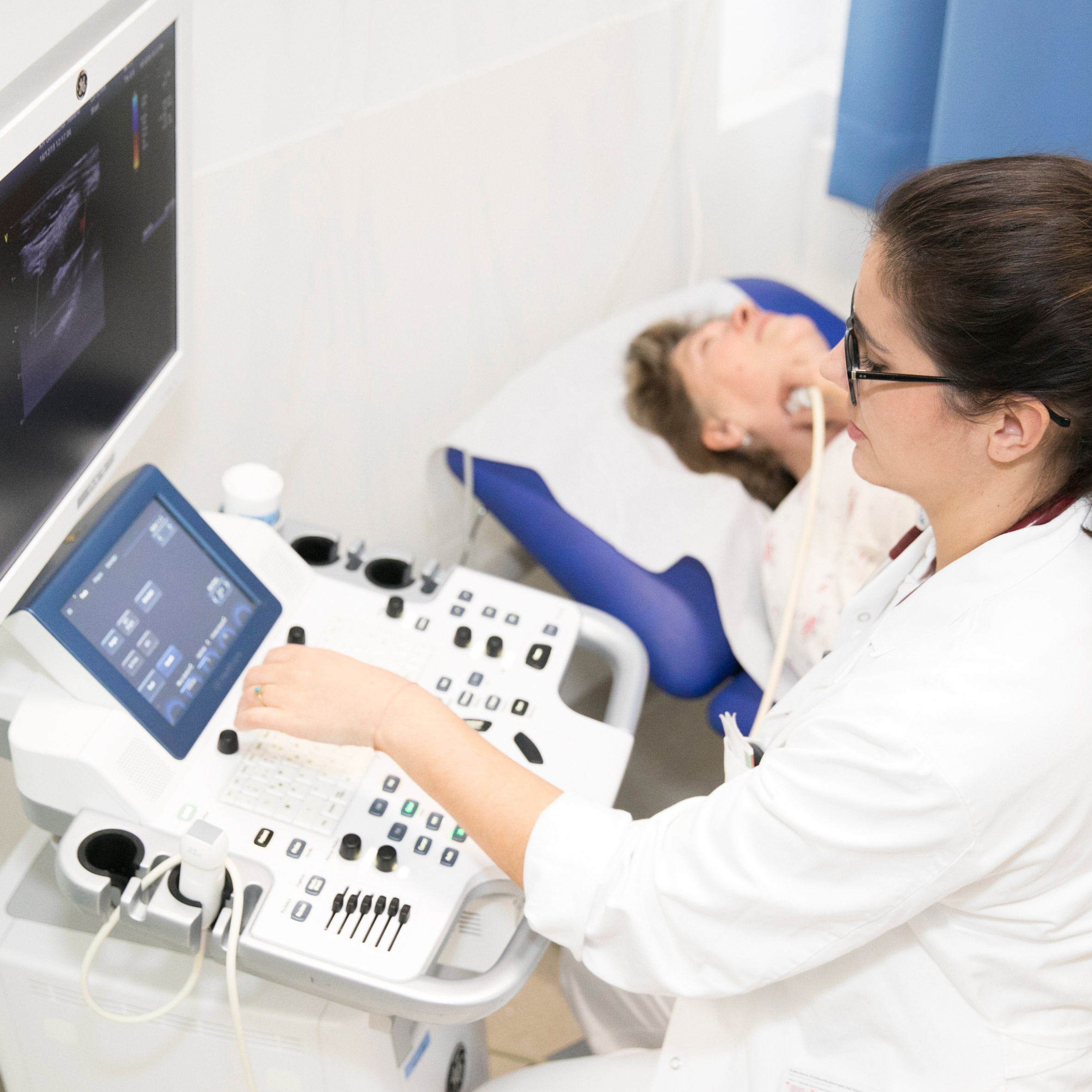 Eine Ärztin untersucht die Halsschlagader einer Patientin