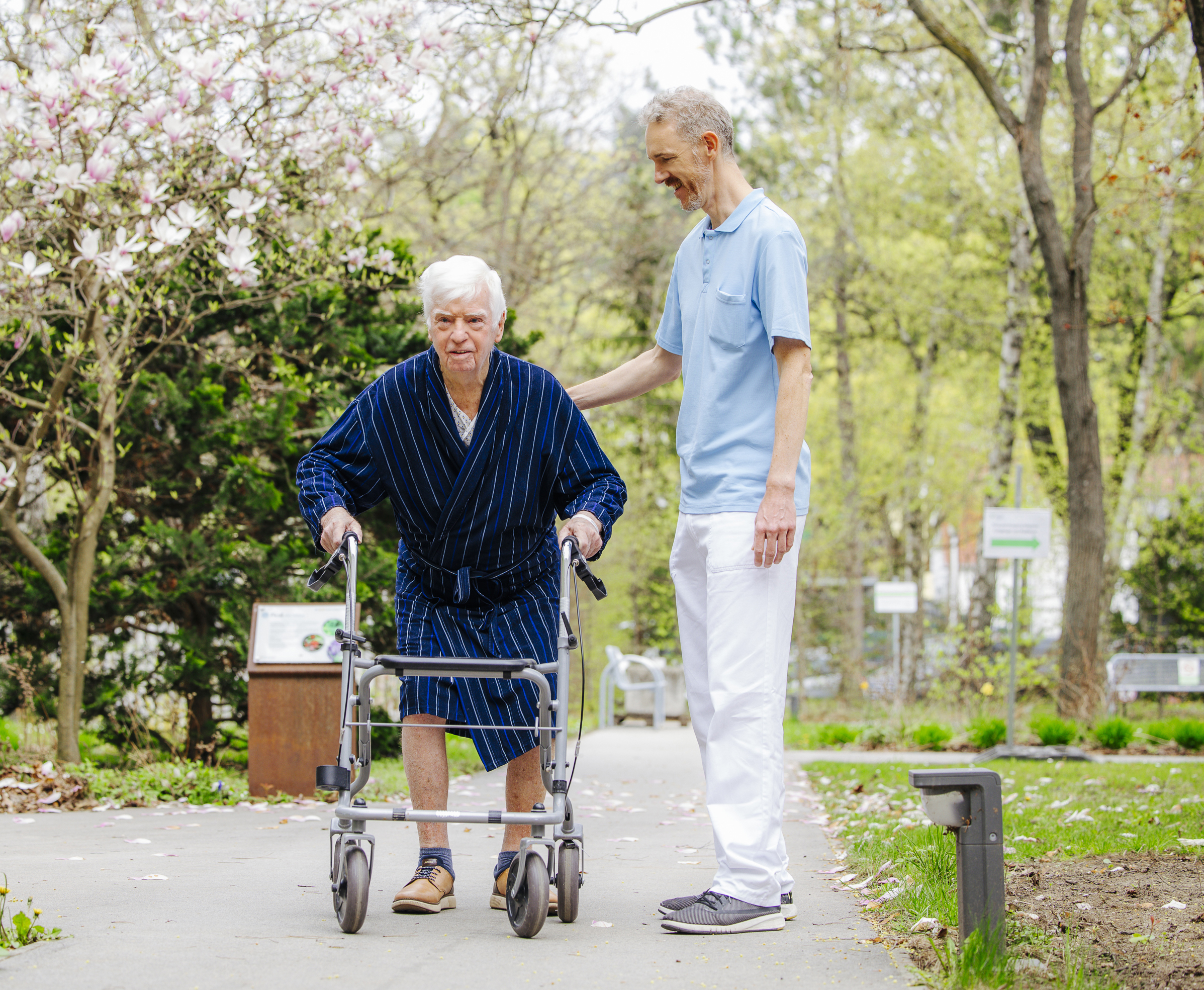 Ein Physiotherapeut und Patient gehen im Garten