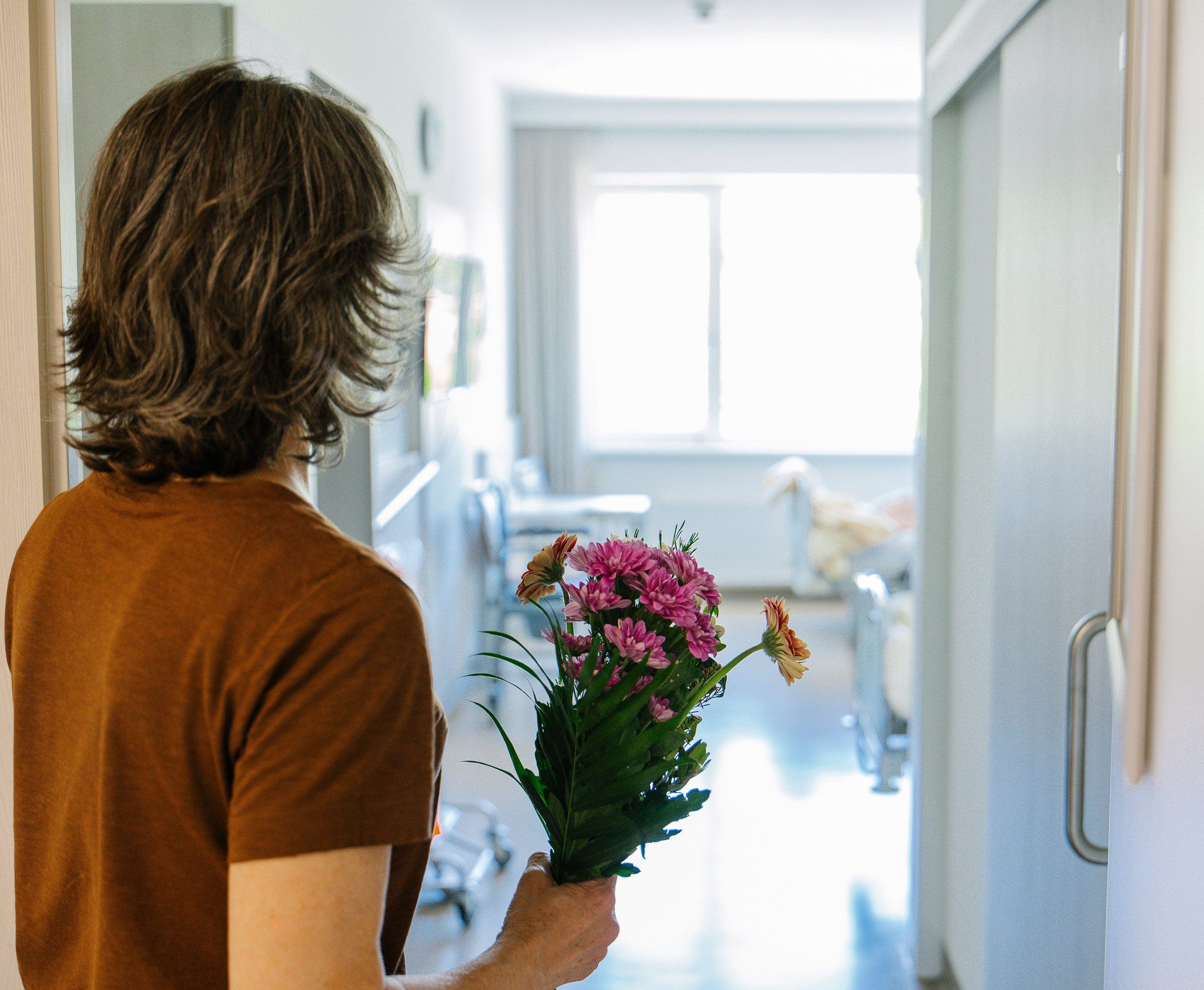 Eine Dame steht mit Blumen beim Eingang zum Zimmer