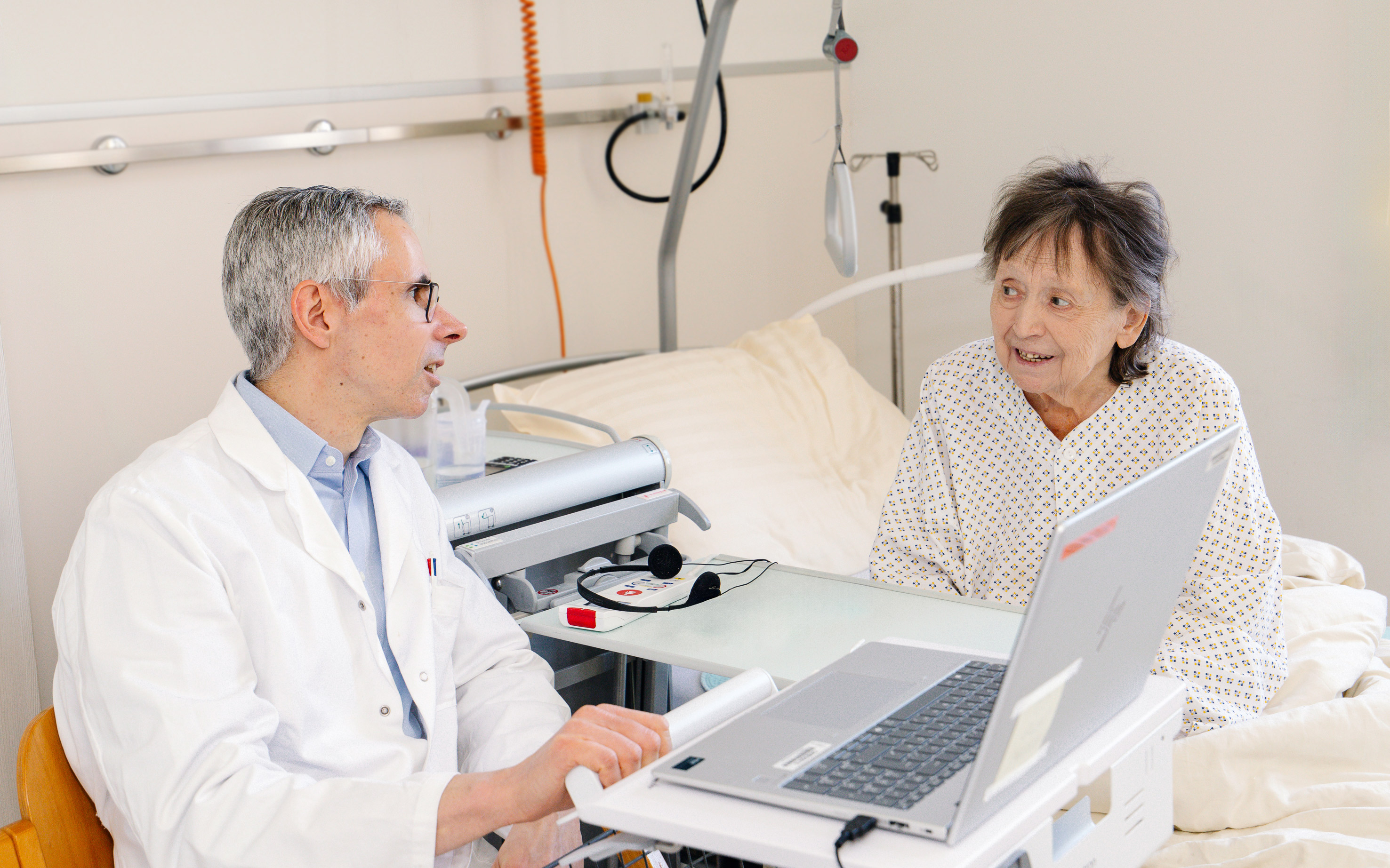 Eine freundliche Physiotherapeutin leitet Patientin bei einer Trainingsgruppe an.