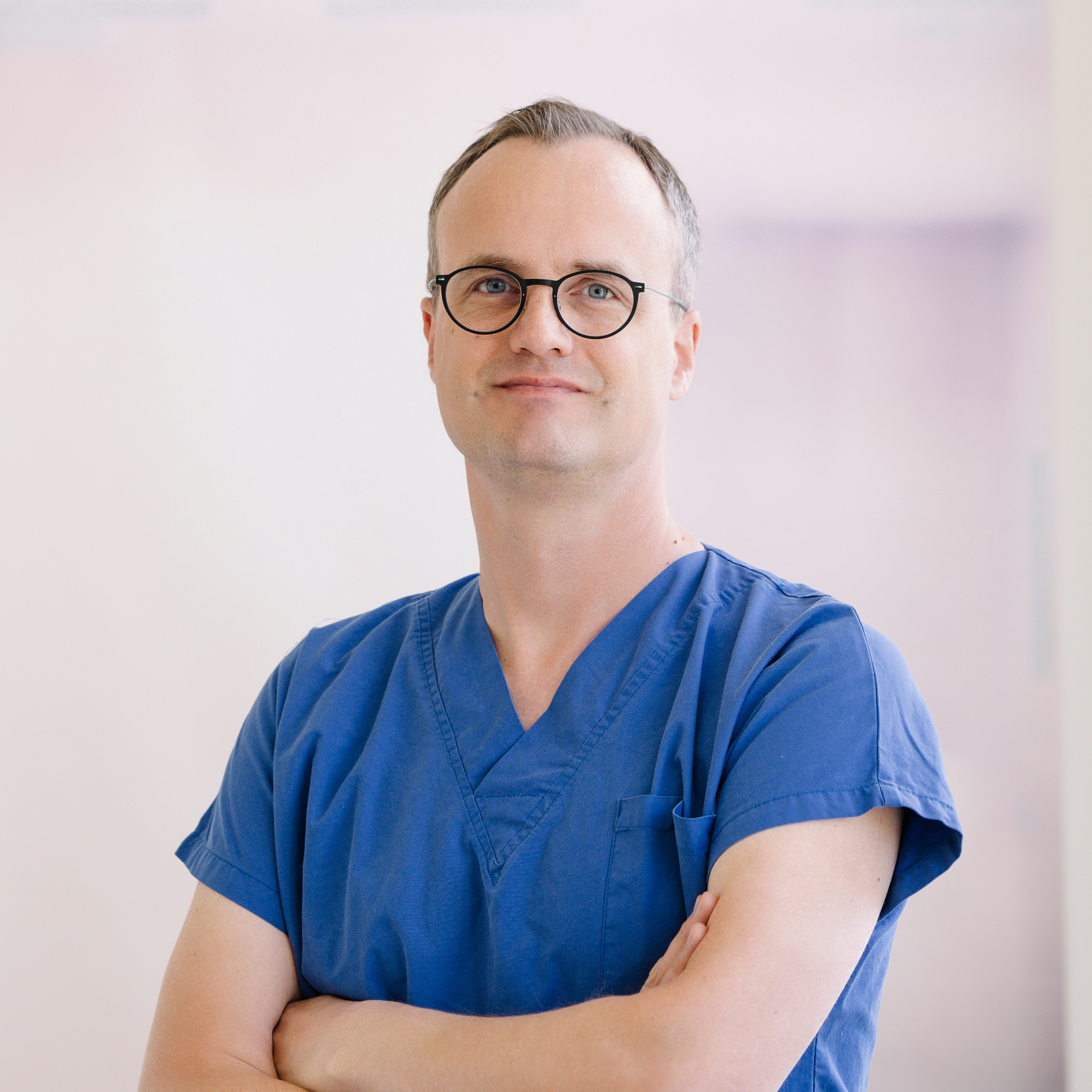 Ein Mann mit kurzen braunen Haaren und Brille