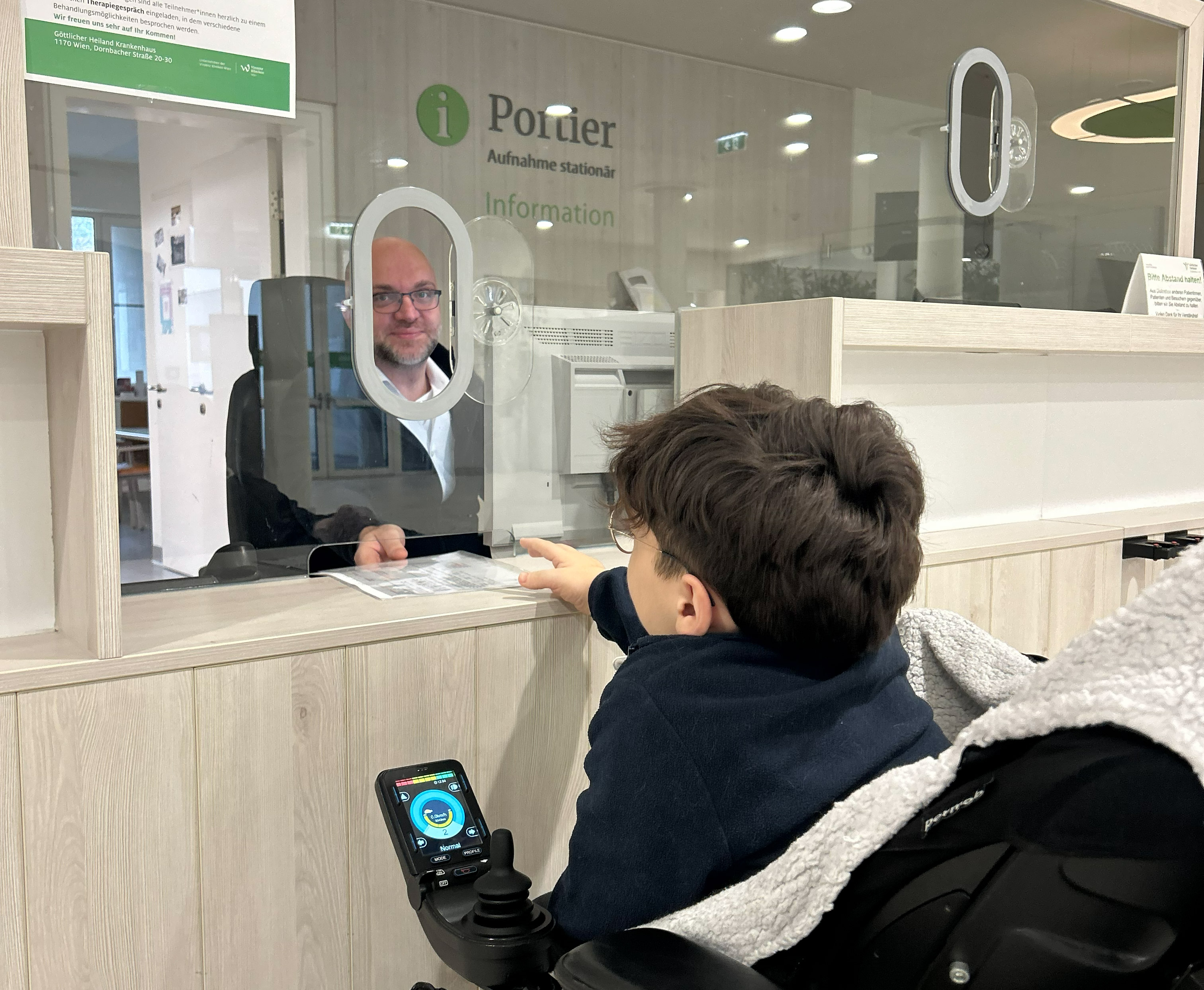 Ein Mann im Rollstuhl auf Augenhöhe mit dem Portier